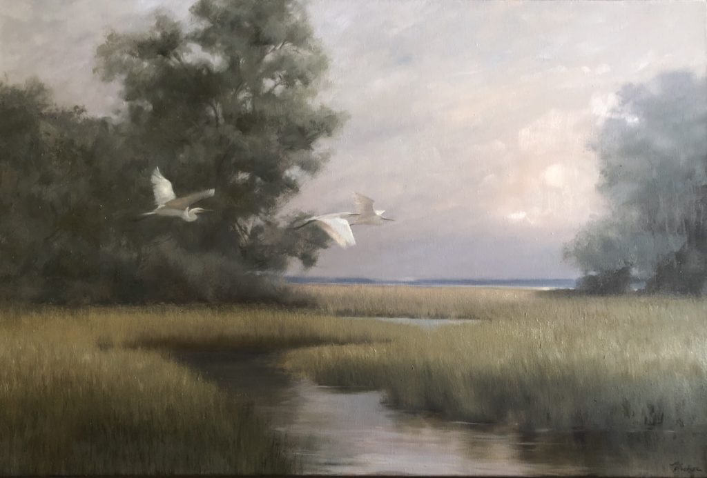 Egrets flying across the marsh